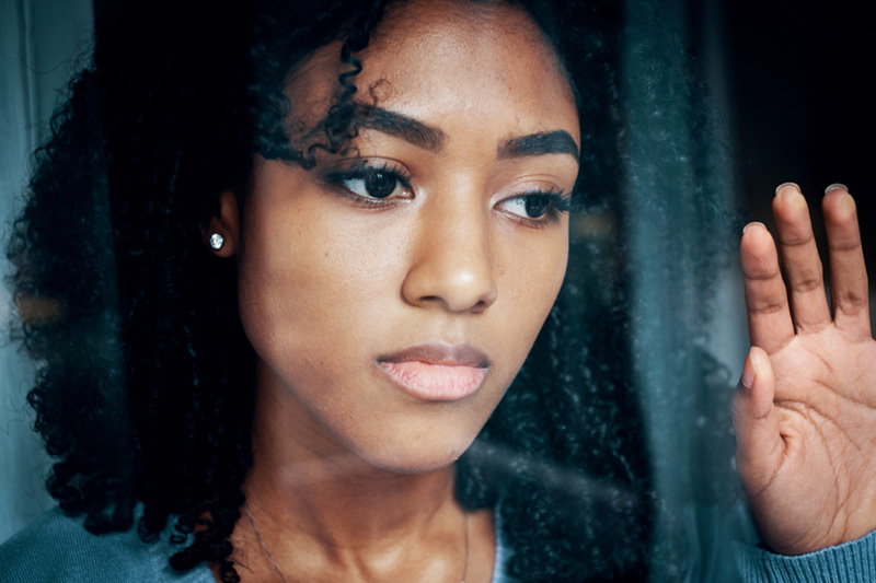 woman looking outside with a serious look on her face